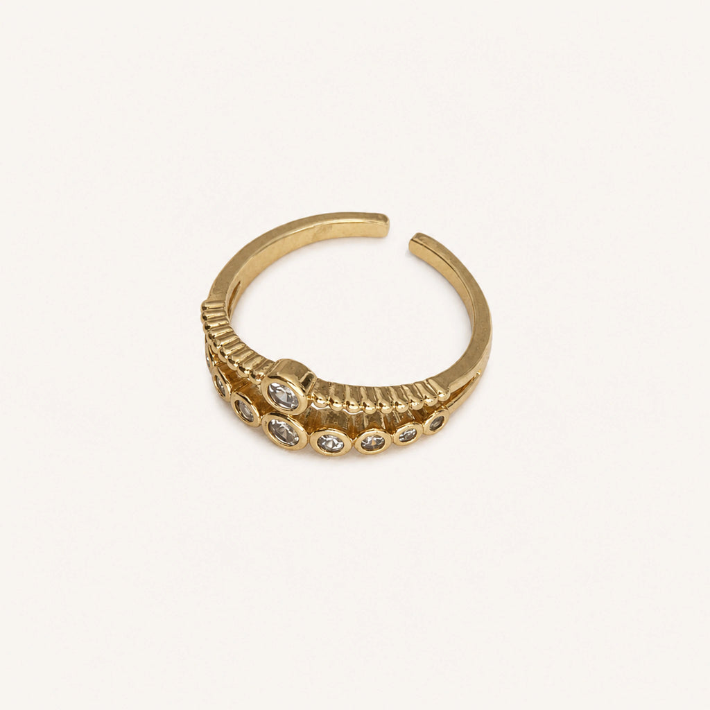 Anillo Compás: banda ajustable con dos recorridos curvos y ocho piedras.