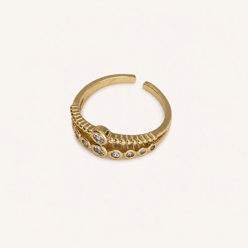 Anillo Compás: banda ajustable con dos recorridos curvos y ocho piedras.