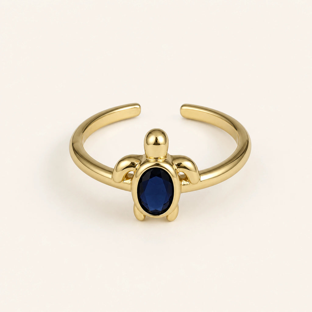 Anillo Tortuga: banda ajustable dorada con motivo de tortuga.
