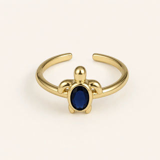 Anillo Tortuga: banda ajustable dorada con motivo de tortuga.