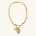 Collar Guadalupe: cadena dorada con medalla ovalada y dije en V.
