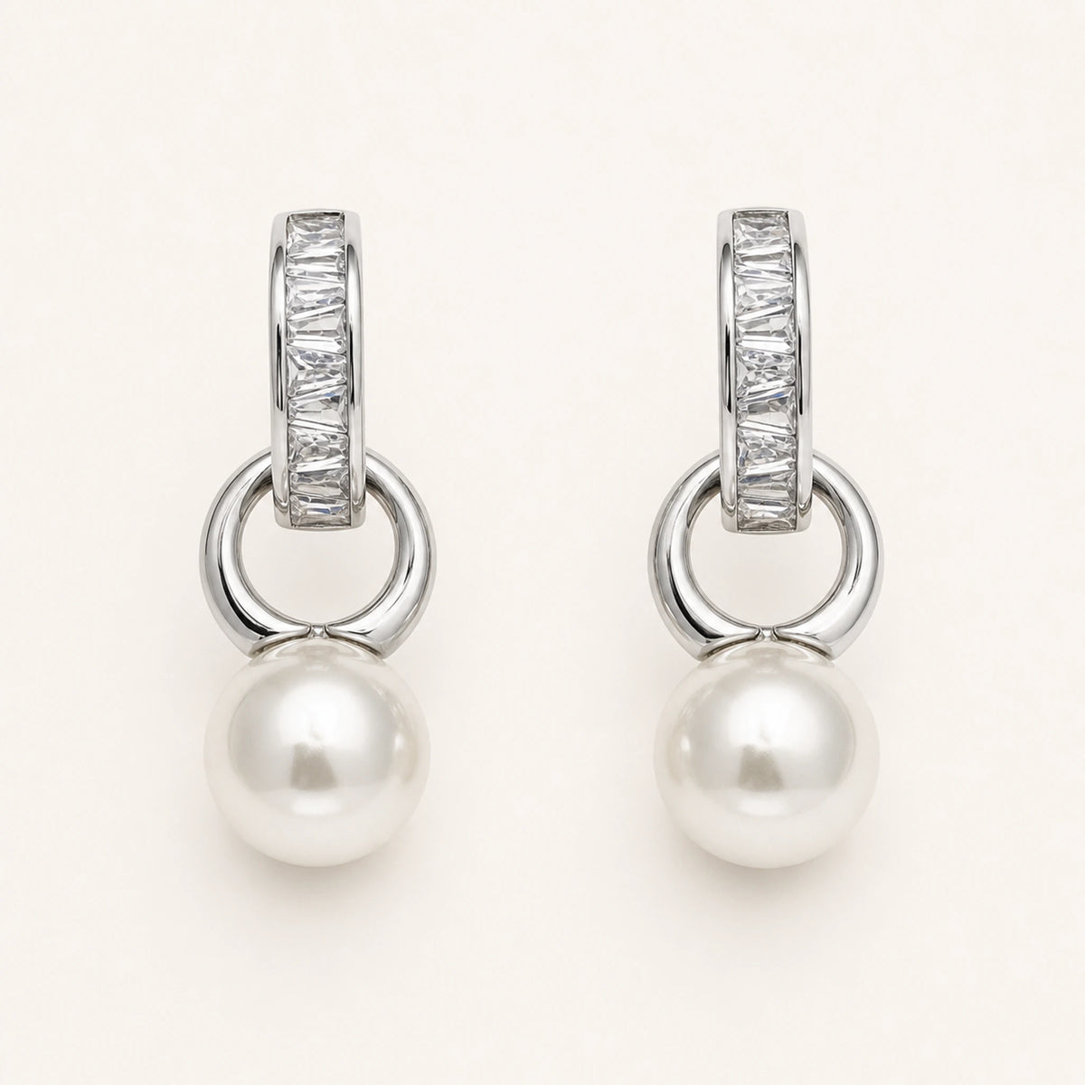 Aretes Gota: barra plateada con esfera blanca colgante.