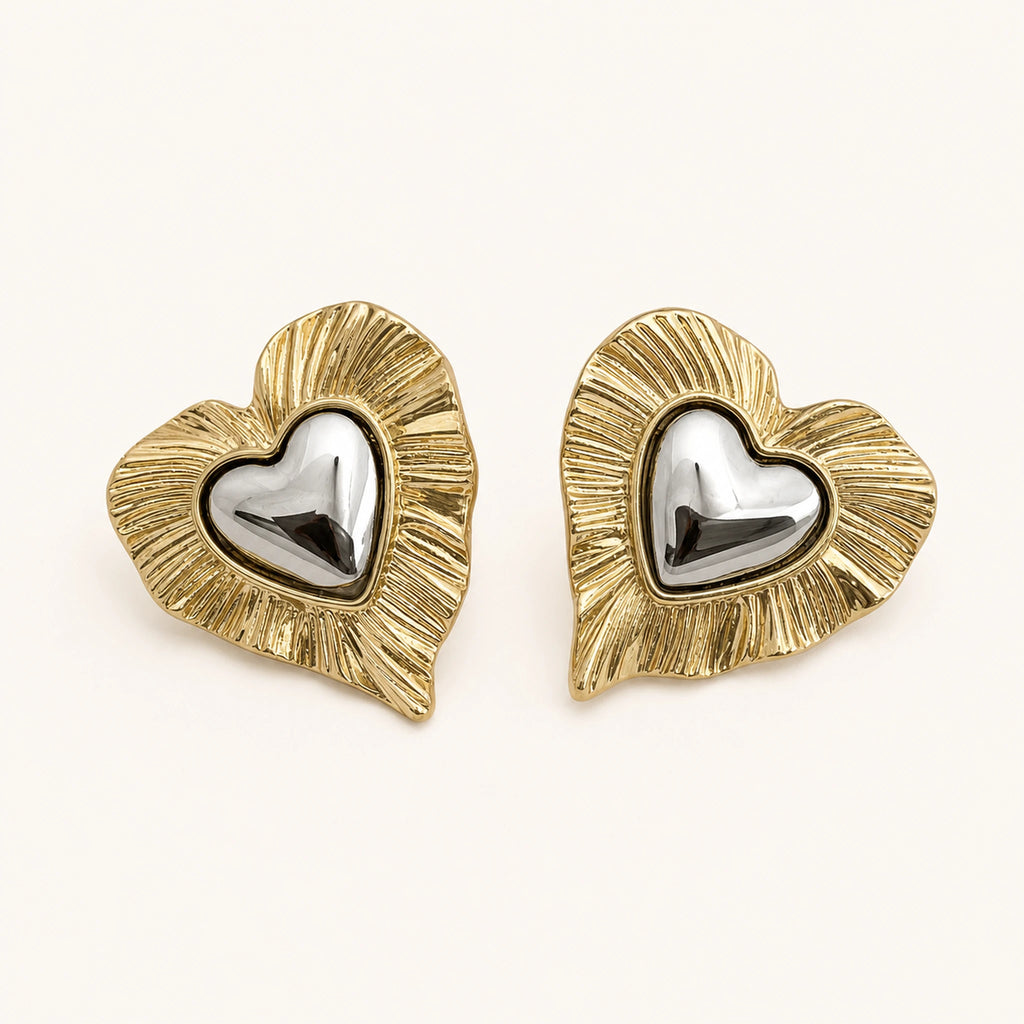 Aretes Doble Corazón: corazón dorado estriado con corazón plateado al centro.