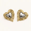 Aretes Doble Corazón: corazón dorado estriado con corazón plateado al centro.