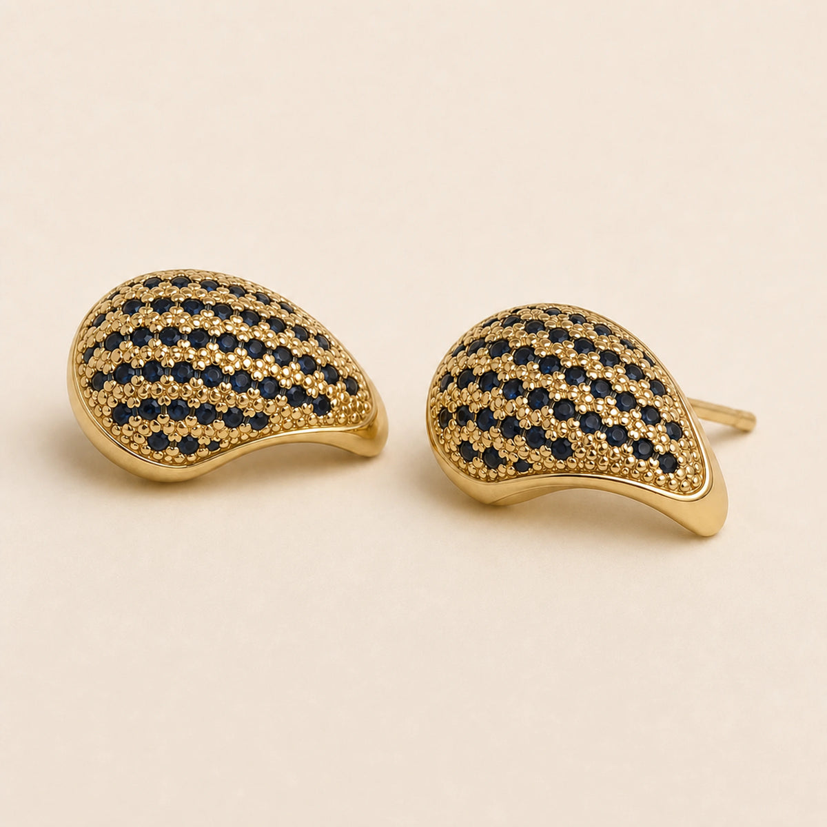 Aretes Pluma: botón curvo dorado con franjas azul marino.
