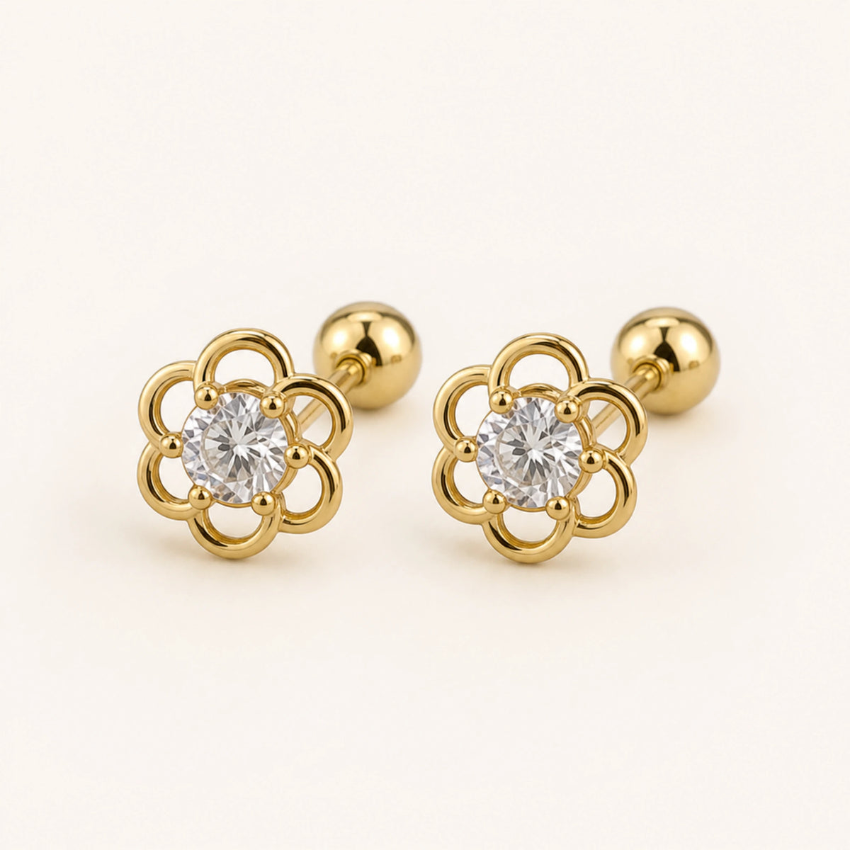Aretes Camelia: flor calada de seis pétalos en oro laminado.
