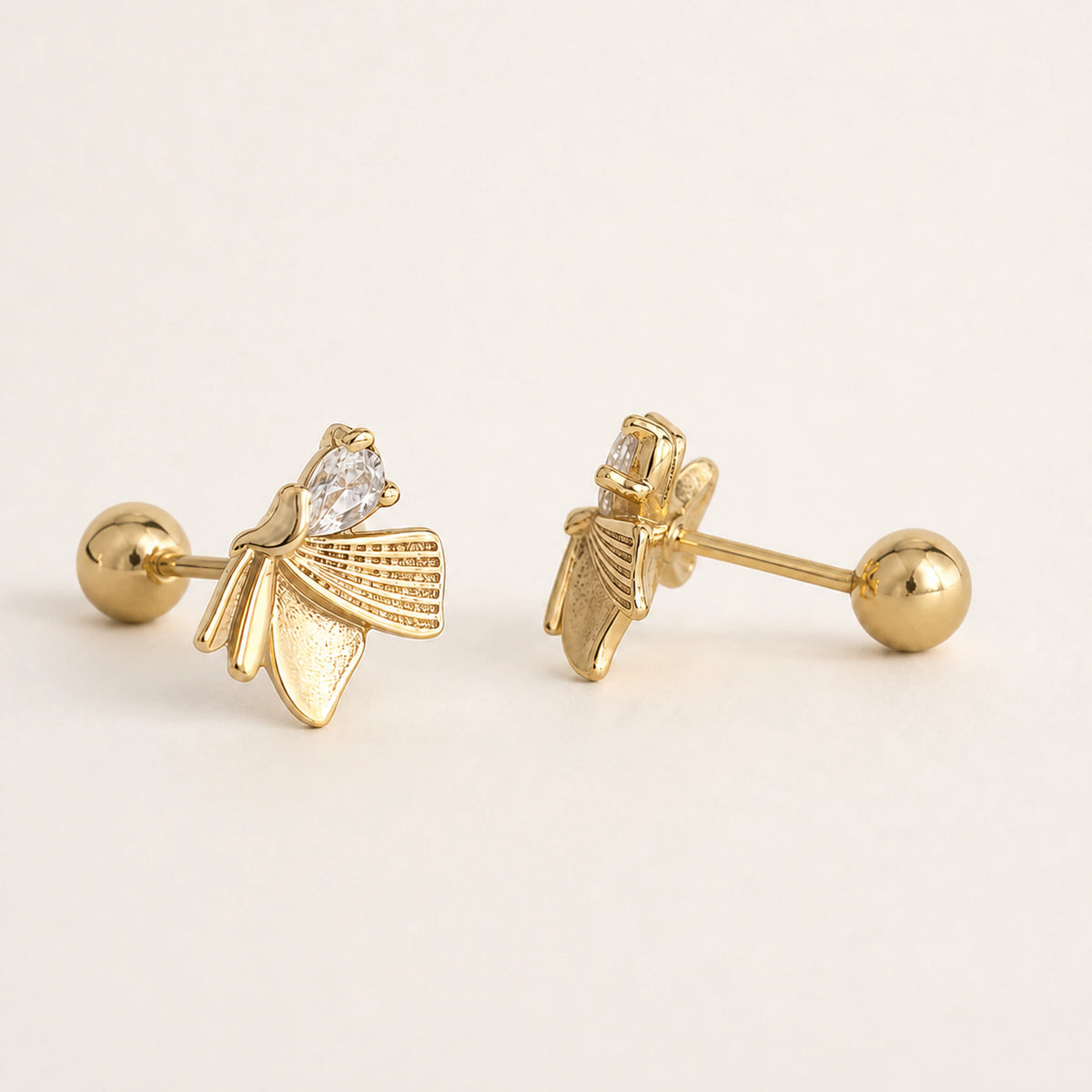 Aretes Brote: composición asimétrica de cinco elementos dorados.